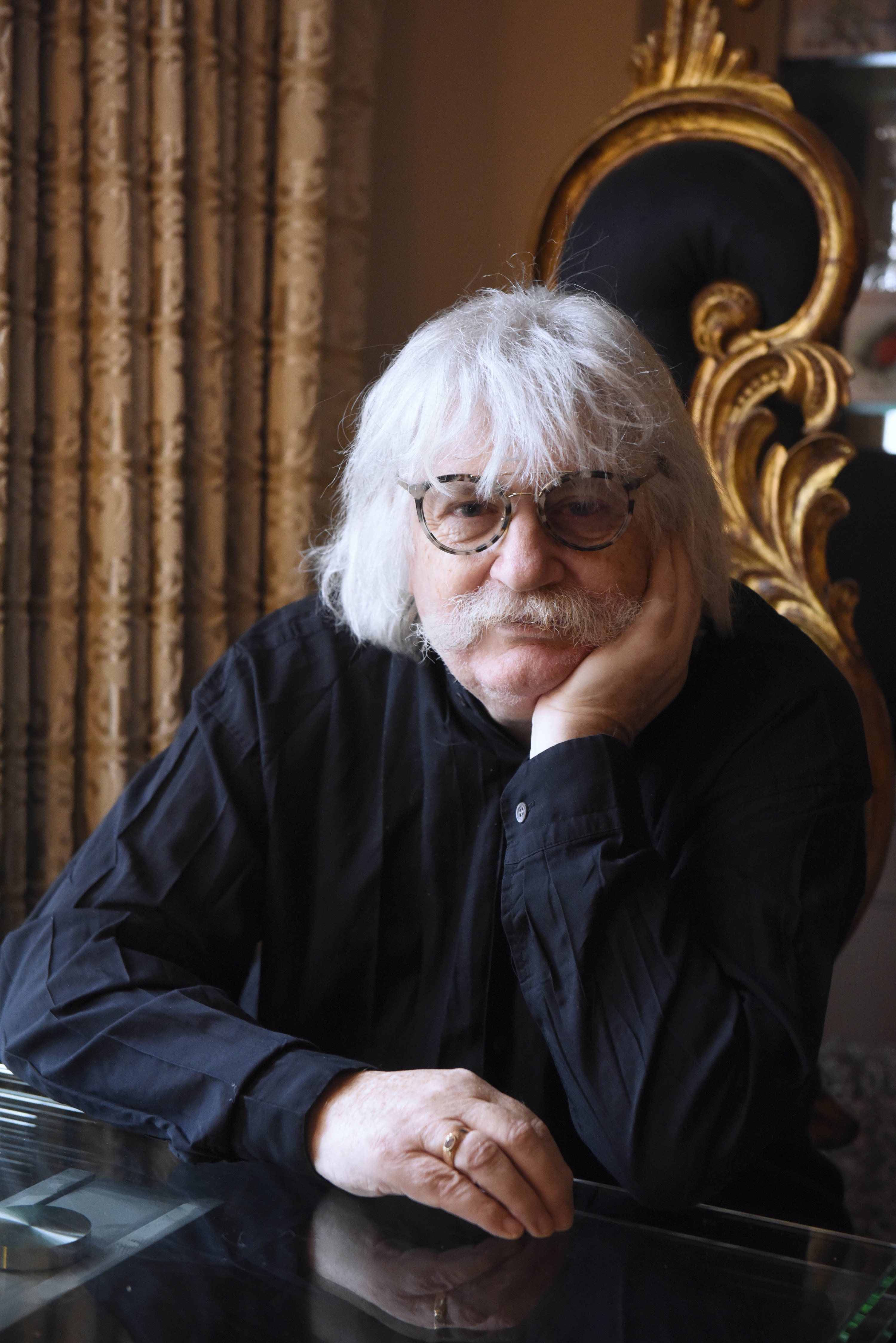 Closeup of Sir Karl Jenkins with his head resting in his hand as he leans on a table