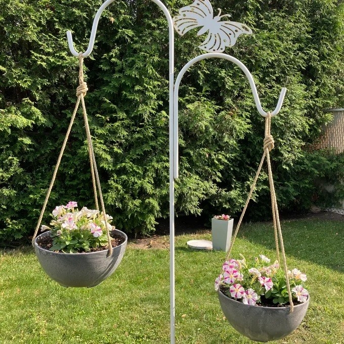 a reviewer photo of two of the hanging planters in a yard