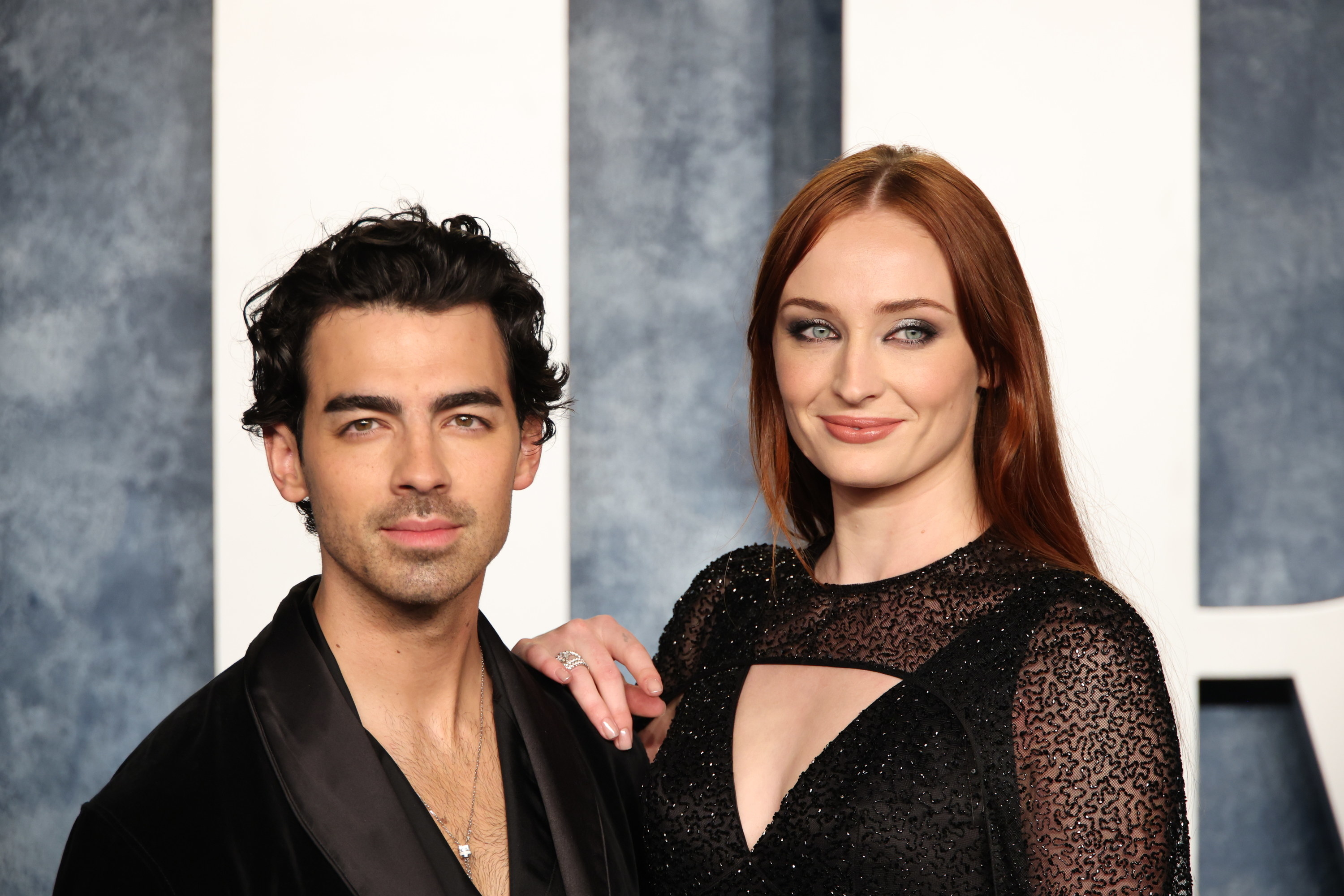 Joe Jonas and Sophie Turner pose on the red carpet with Joe looking into the camera and Sophie slightly angled away with her hand resting on Joe&#x27;s shoulder
