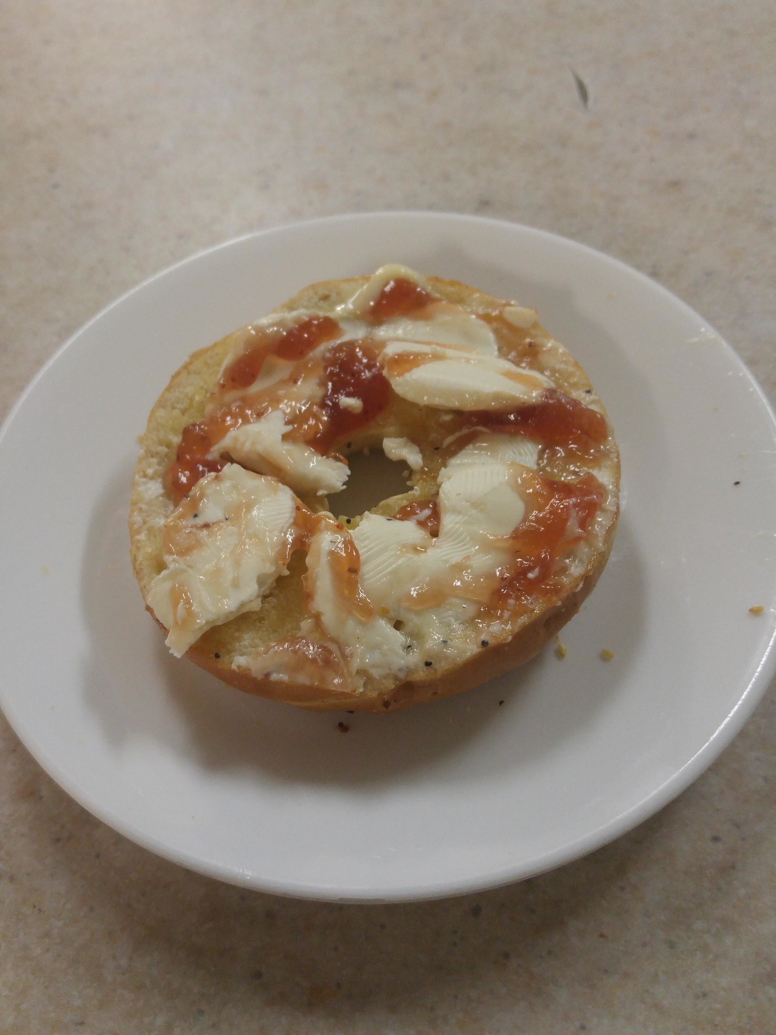A bagel with cream cheese and jelly.