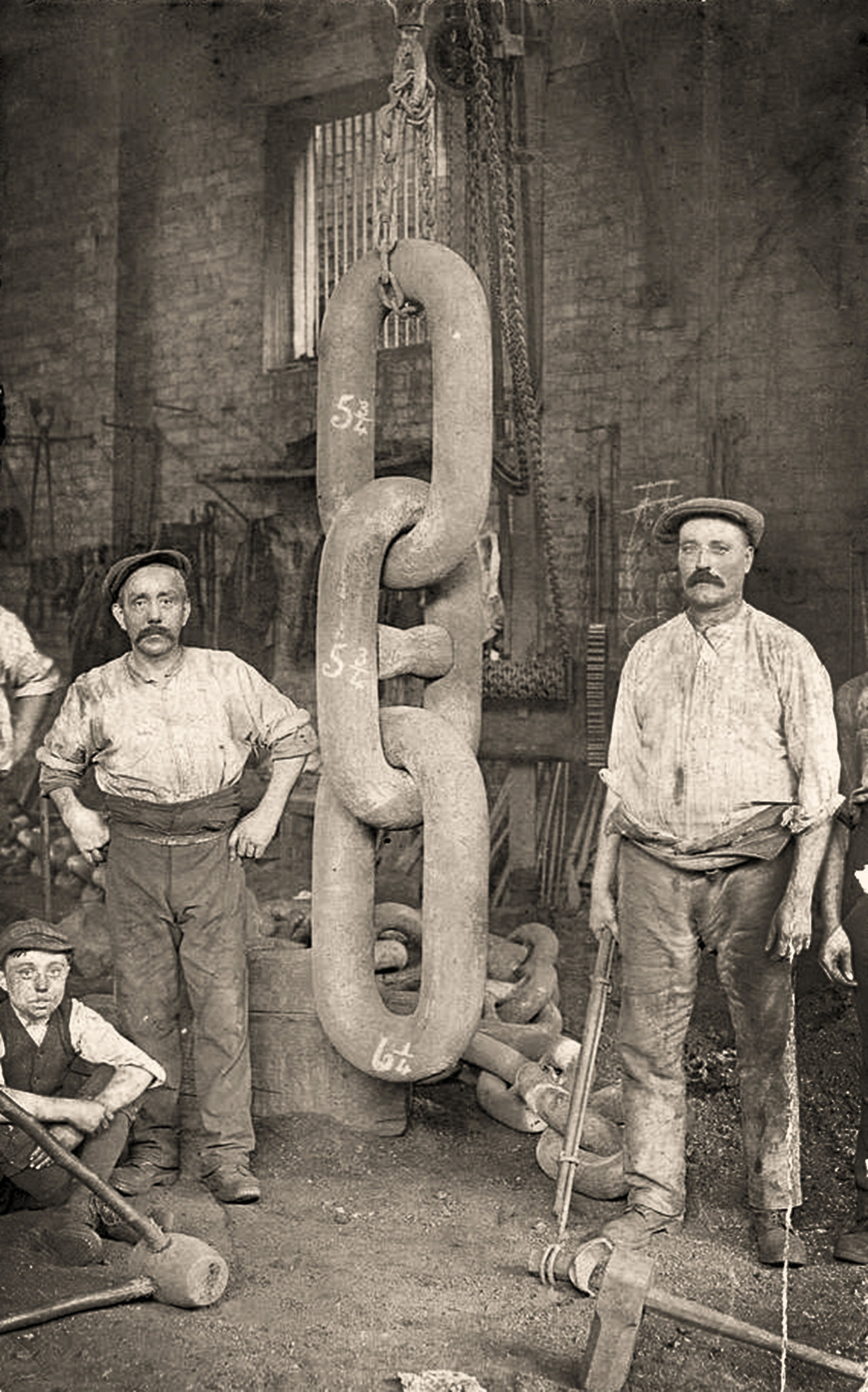 Men standing next to a giant chain