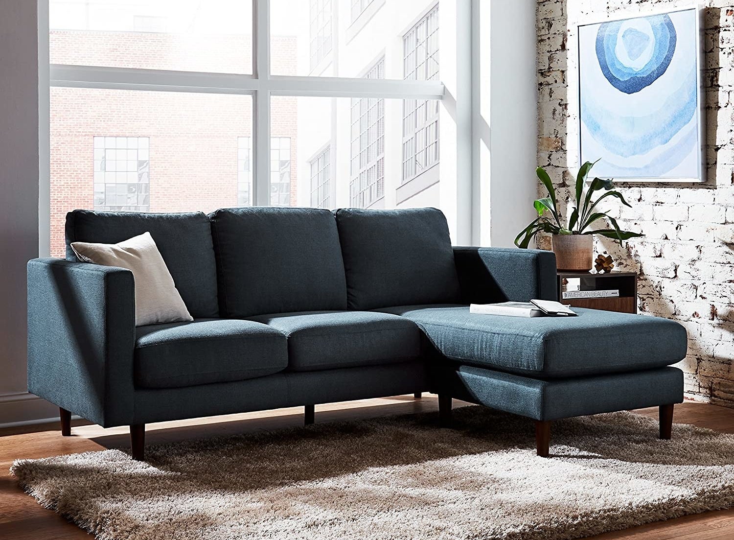 A navy blue sectional is shown in a living room