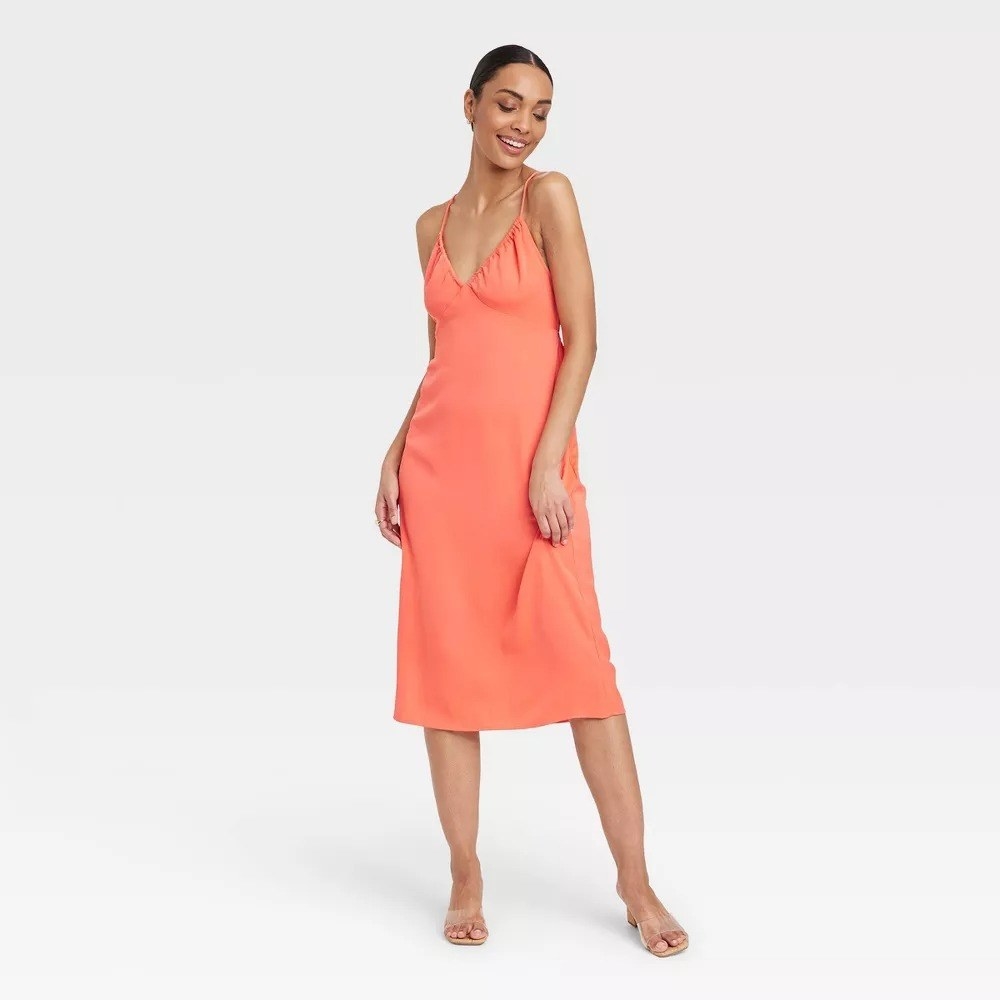 a model wearing the orange slip dress