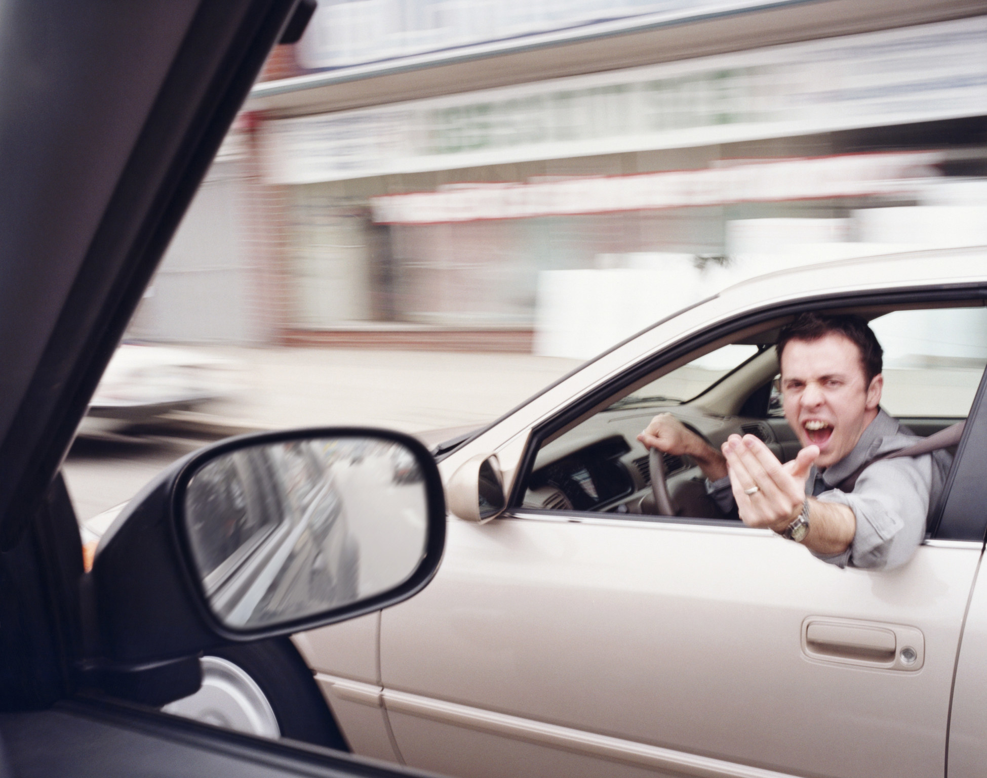 A man yelling at someone from his car