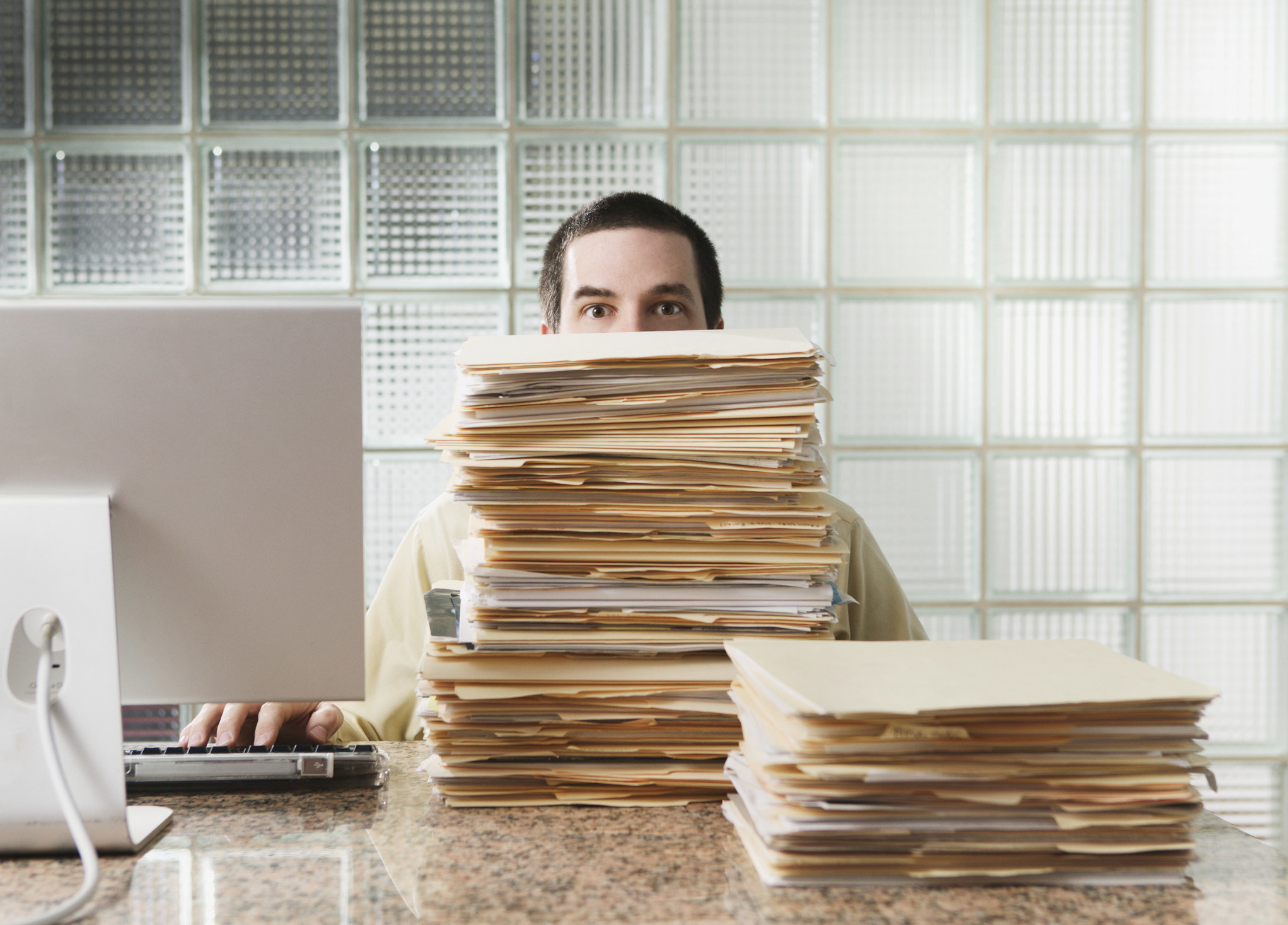 A man with a stack of files in front of him