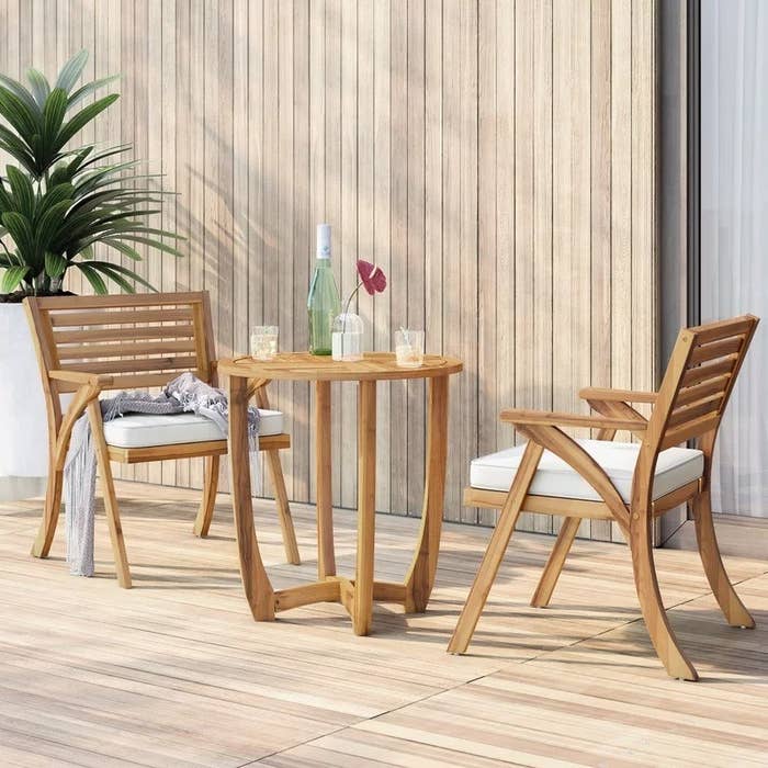the light brown bistro set with two chairs and a table on a patio