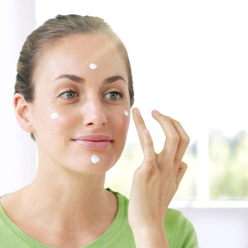 A person applying moisturizer to their face