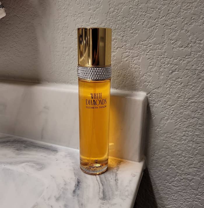A reviewer&#x27;s photo of a sleek bottle of yellow perfume
