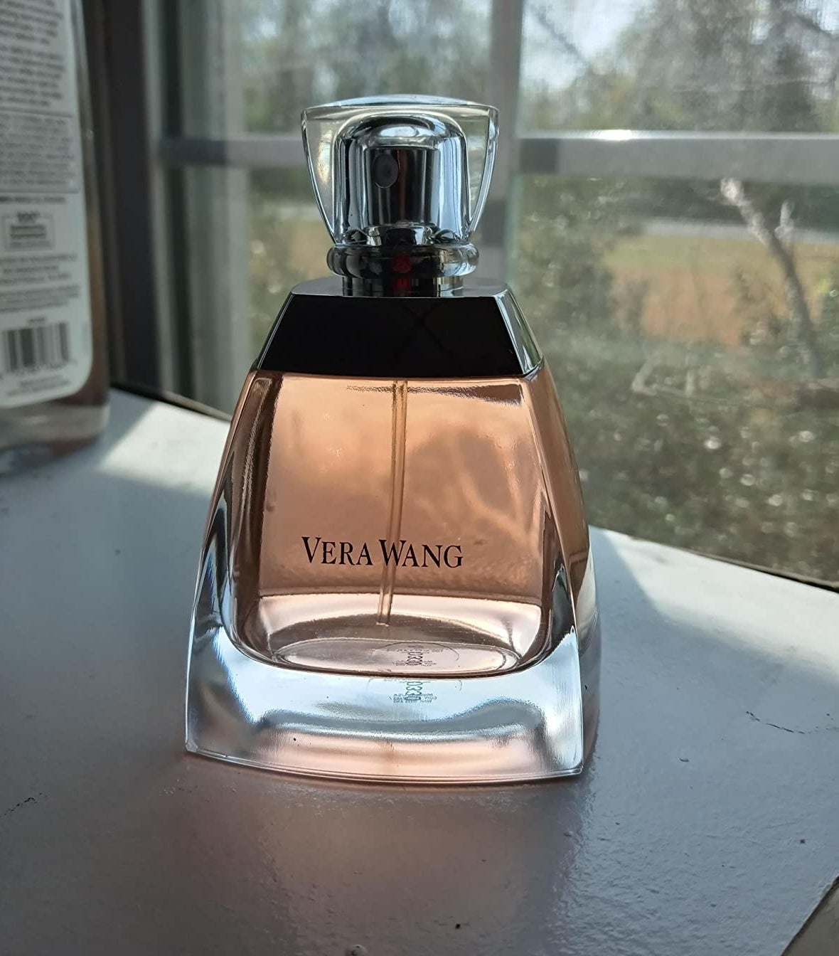 A reviewer&#x27;s photo of a light orange bottle of perfume