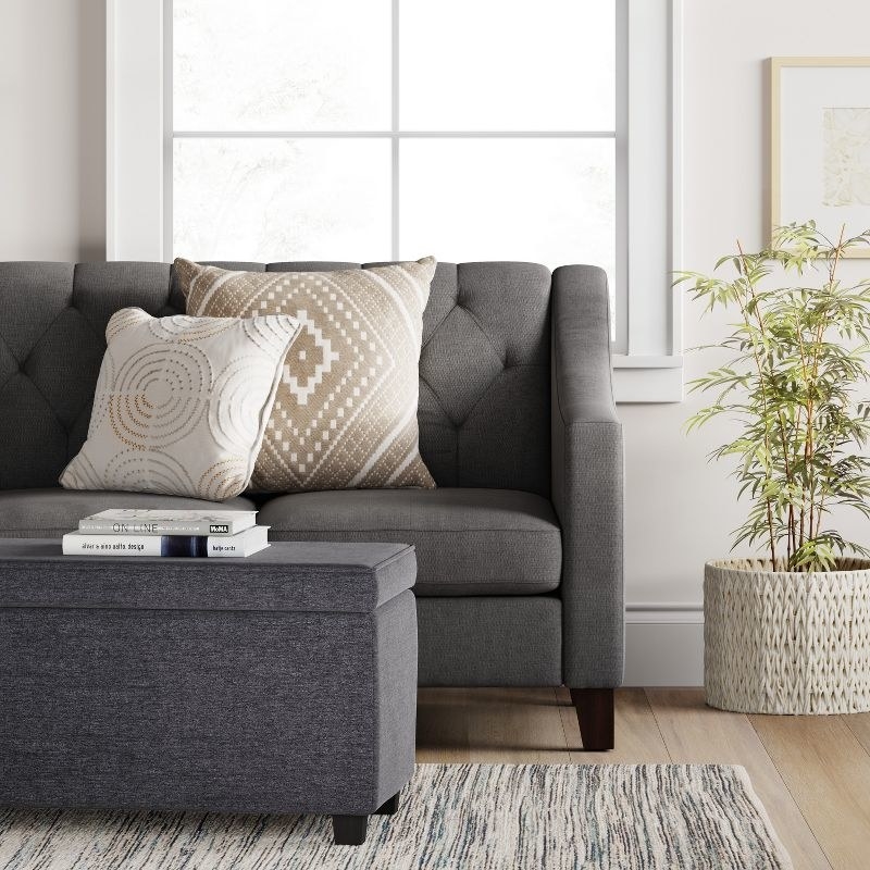 a gray double storage ottoman in front of a gray couch in a living room
