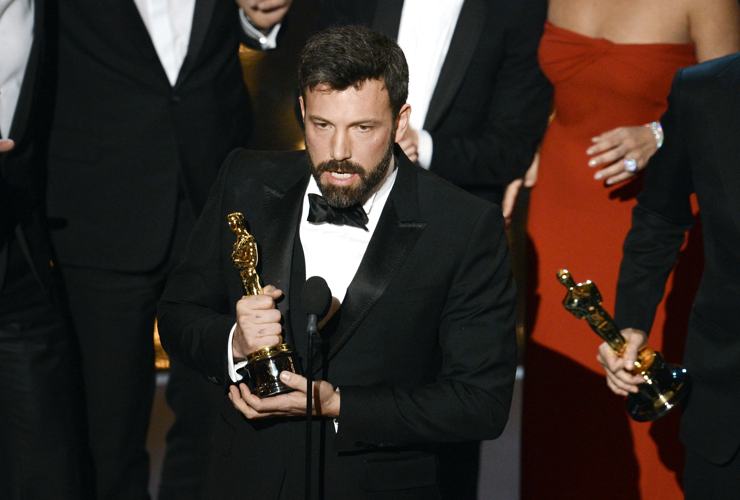 Ben holding an Oscar at a podium