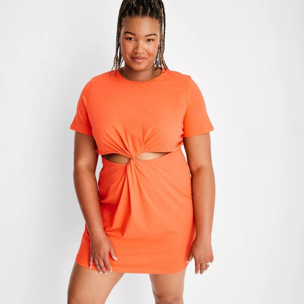 A model in the orange cut-out dress