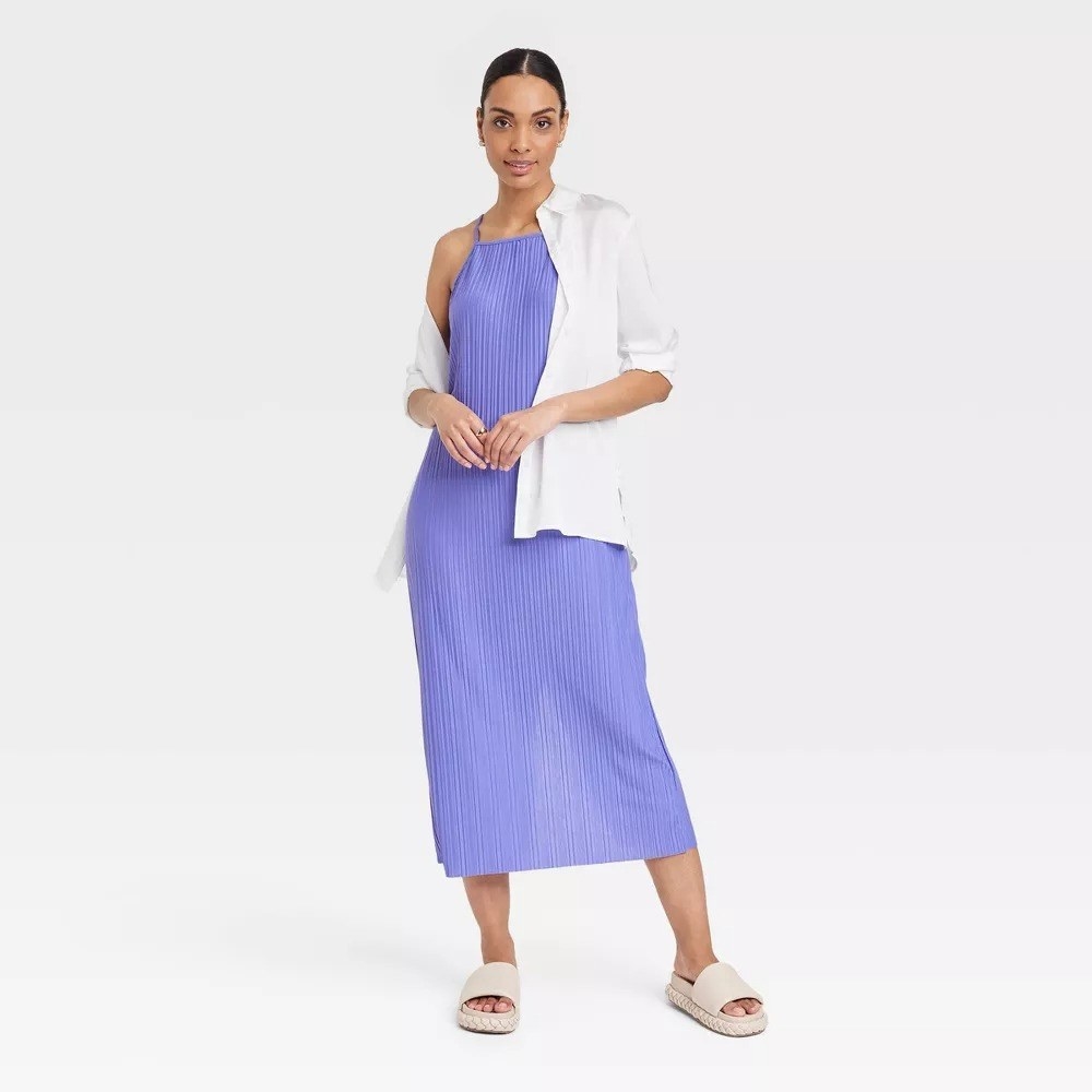 A model in the lavender dress with a white button-up