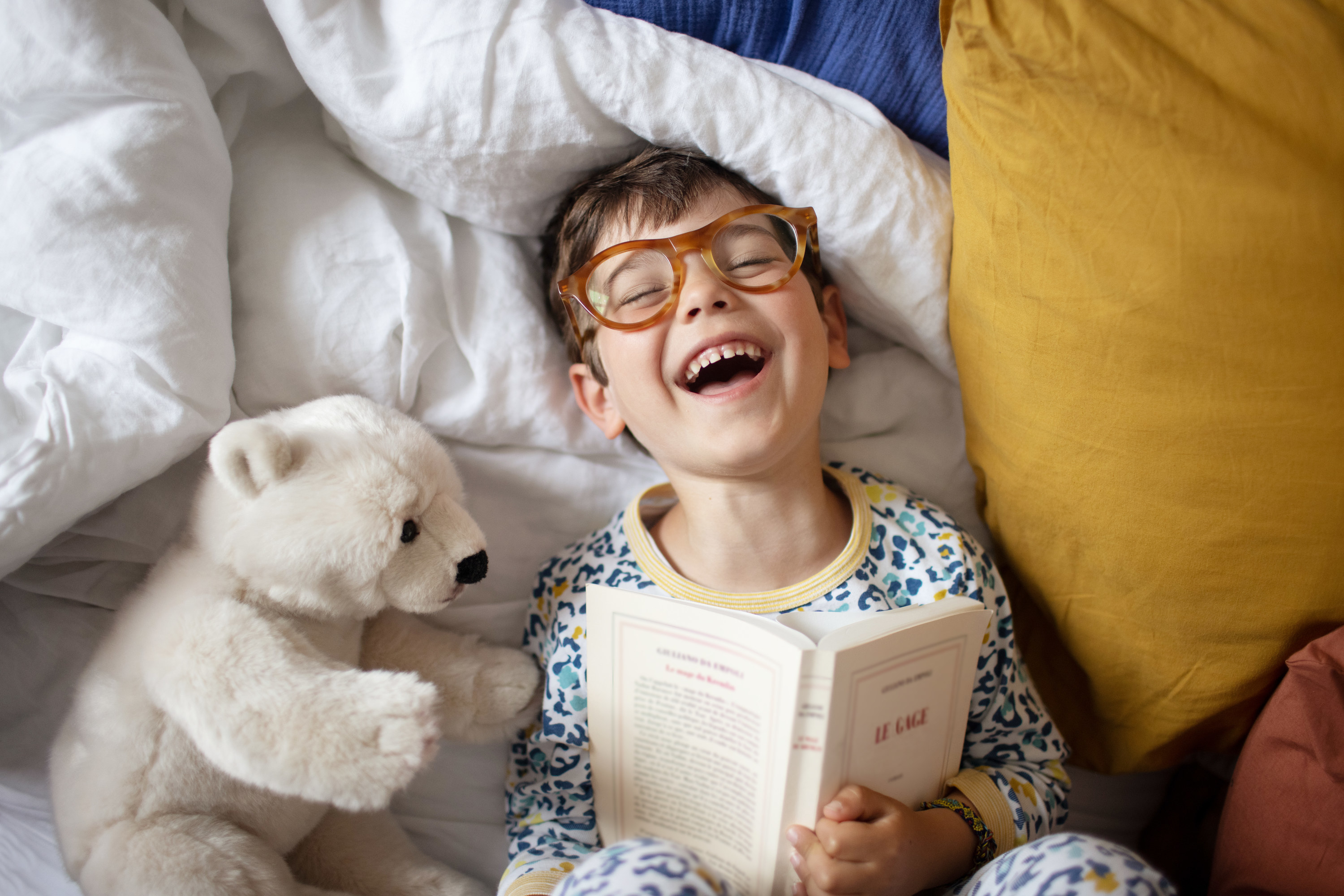 a kid laughing with a book