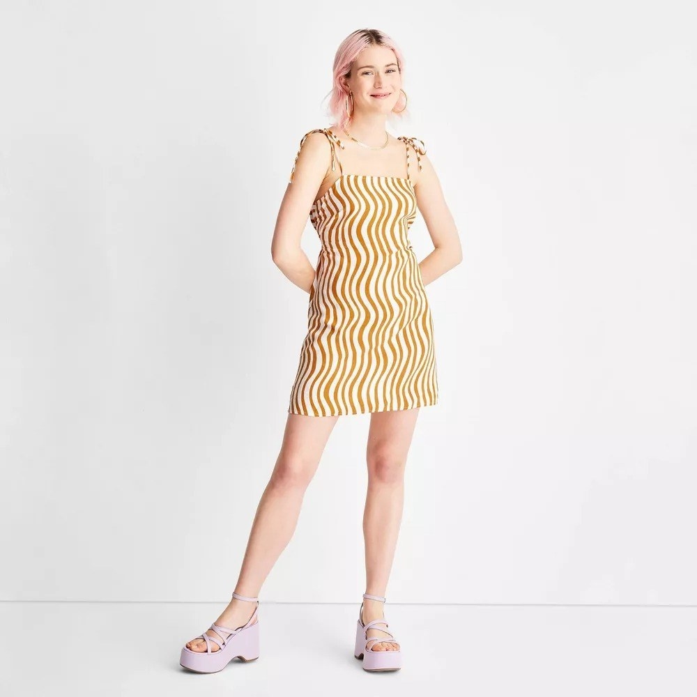 A model in the saffron and white wiggly striped dress