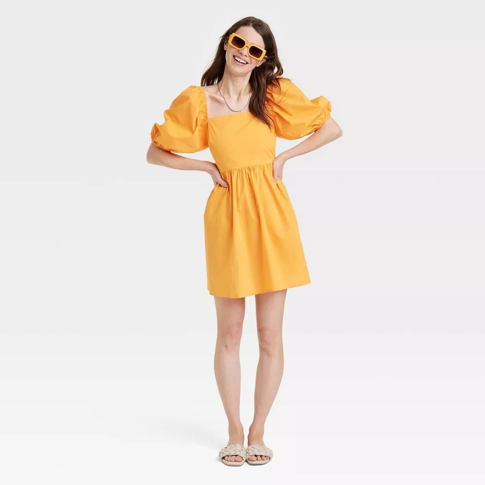 A model in the yellow puff sleeve dress