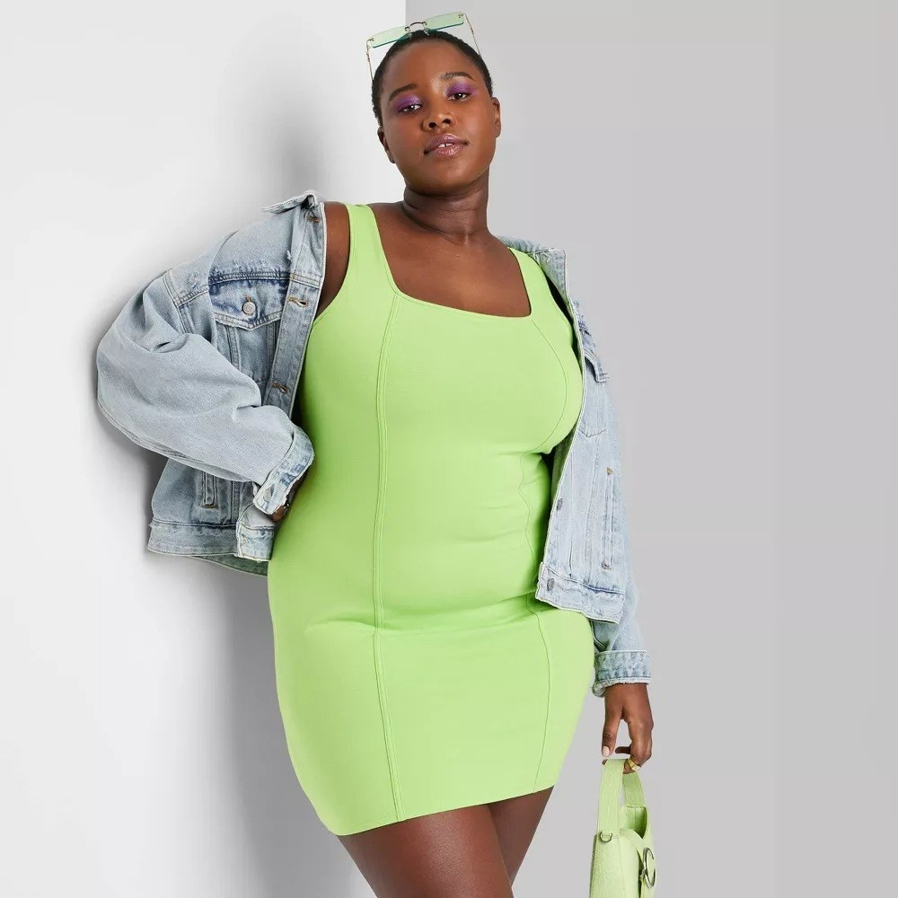 A model in the highlighter green bodycon dress