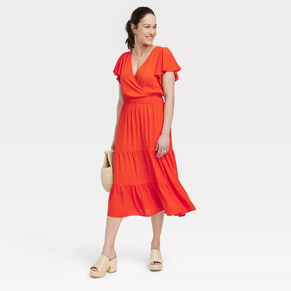 A model in the red midi dress