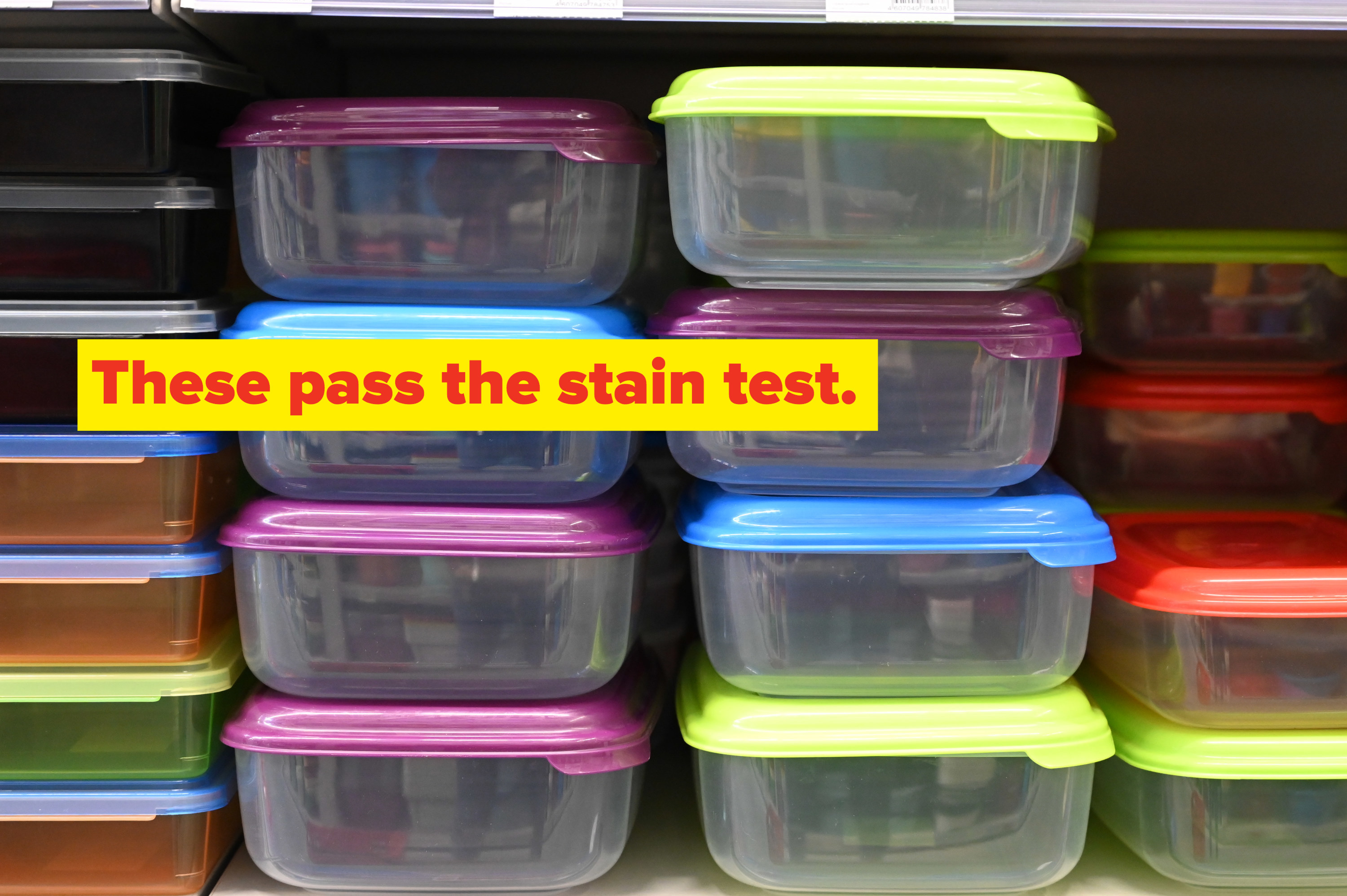 A variety of sizes of plastic food storage containers stacked inside of a cabinet