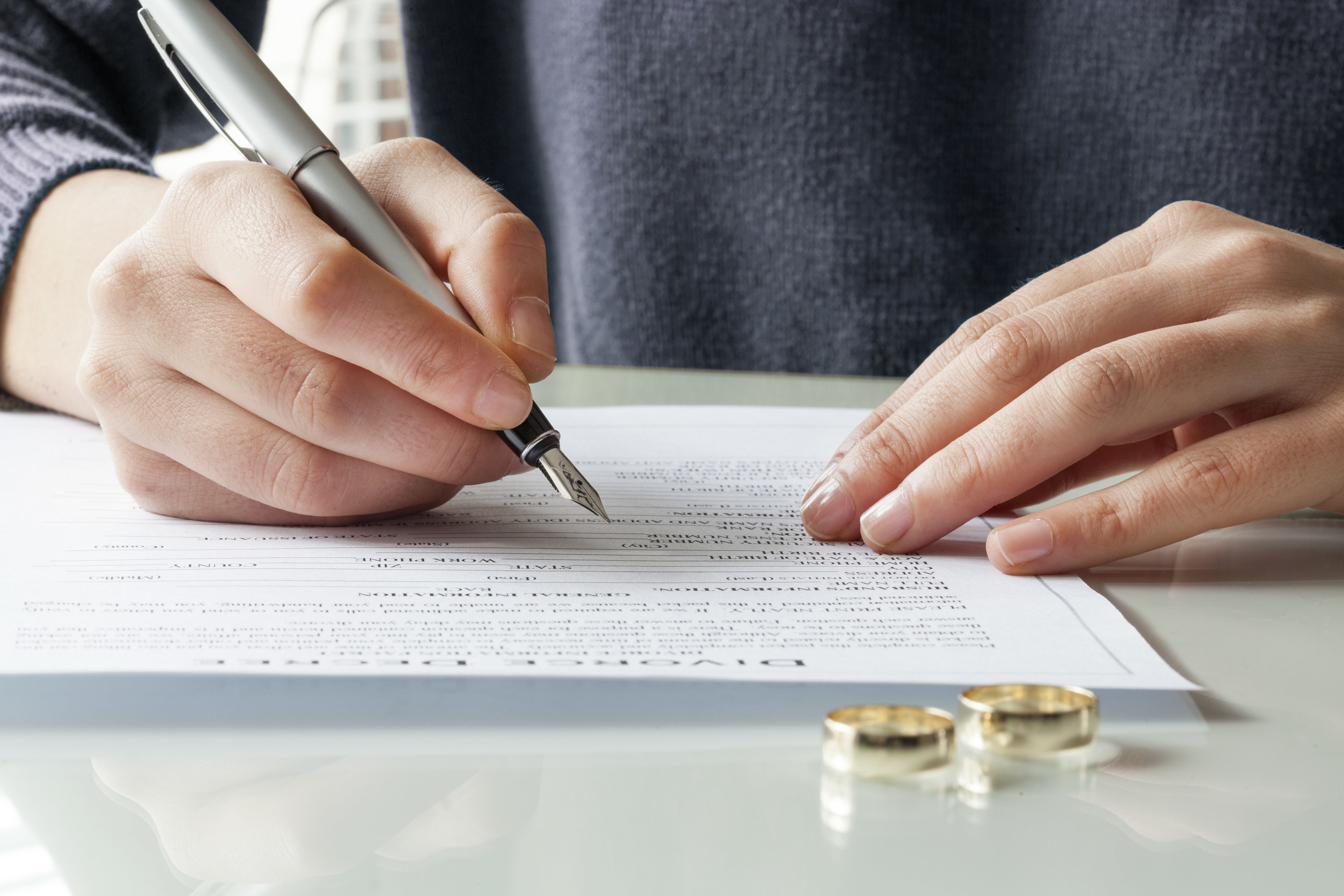 A woman signs a divorce document