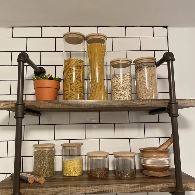 large and small glass canisters filled with pasta, oats, and spices on shelves