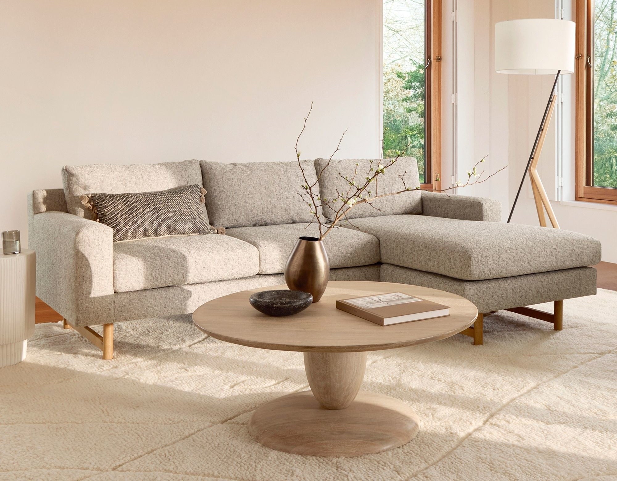 A beige linen sectional is shown in a tasteful living room