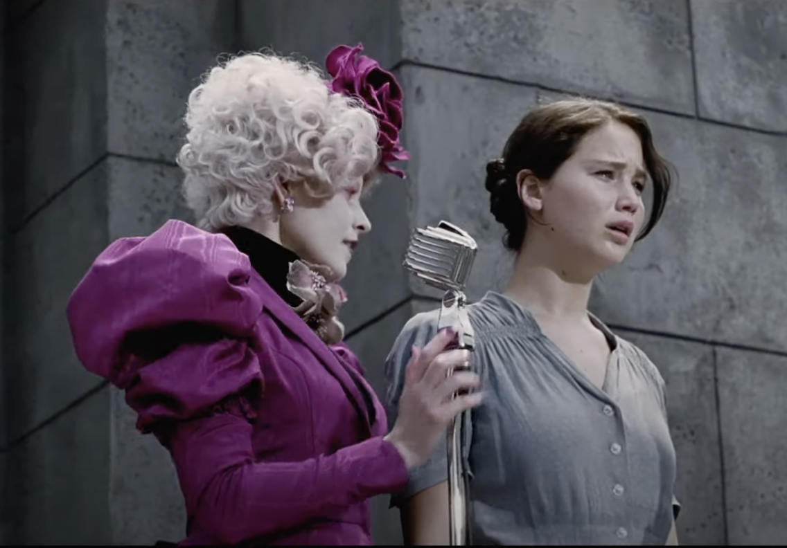 Effie and Katniss standing on the stage at the reaping ceremony