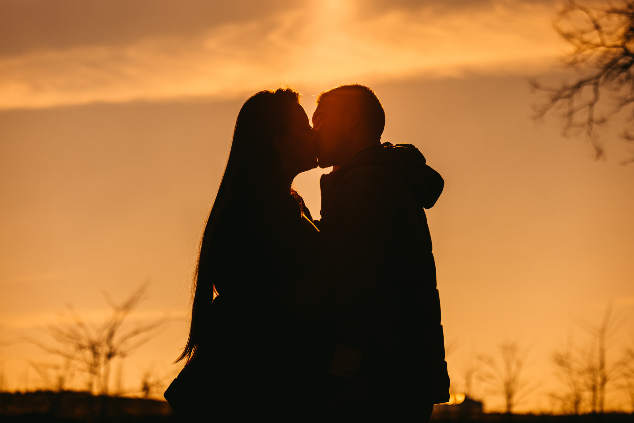 Two people kissing in the sunset