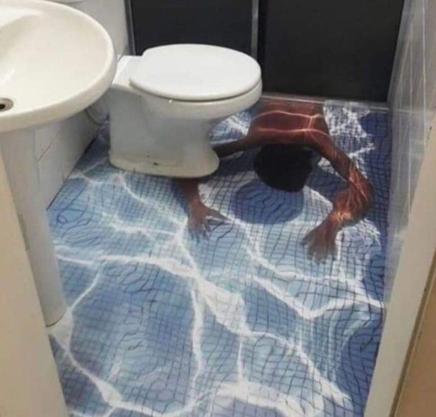 A floor painted to look like someone is swimming under the toilet