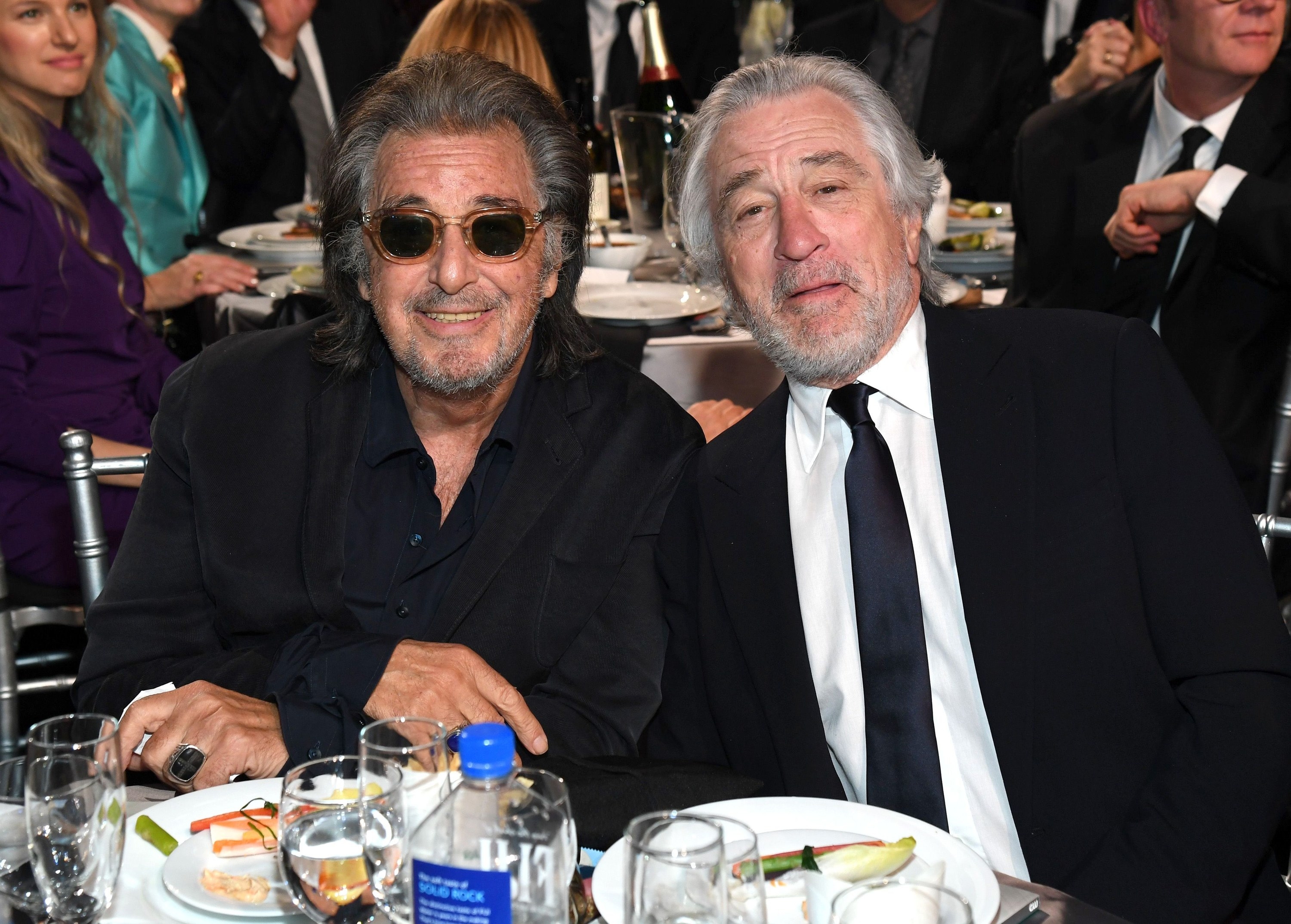 Pacino and De Niro sitting together and smiling