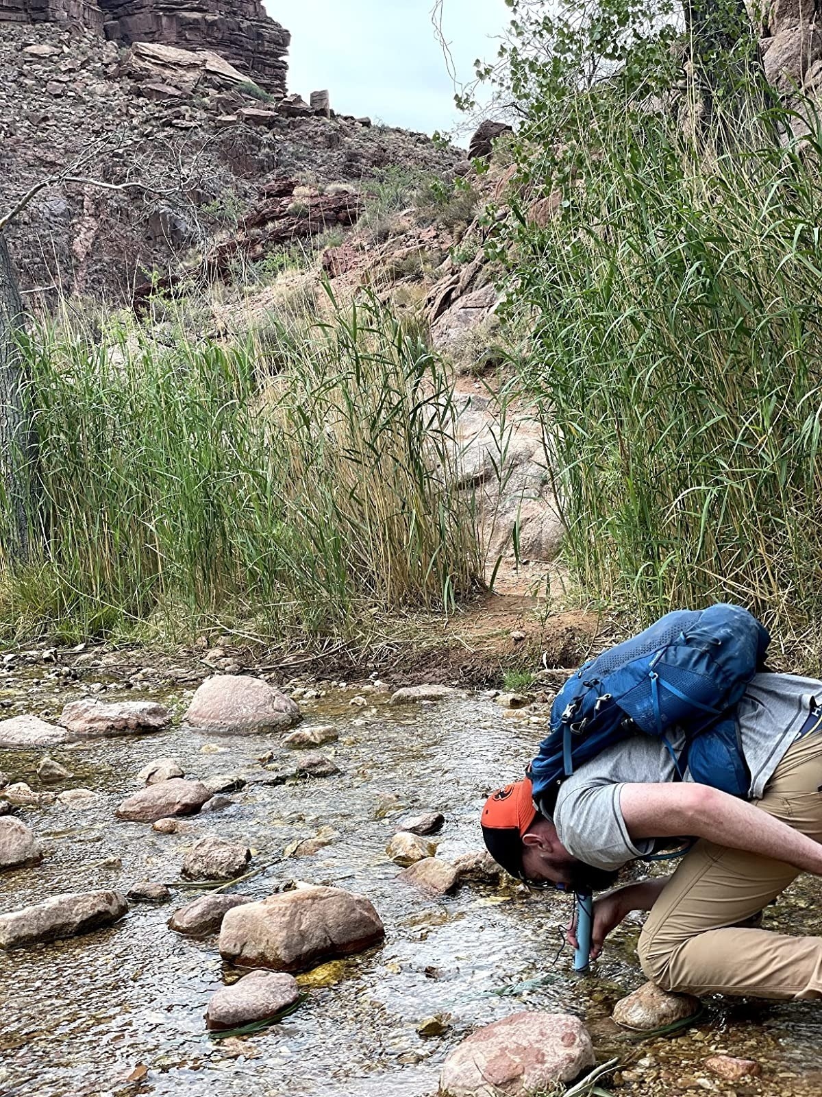 Reviewer using the LifeStraw in a river
