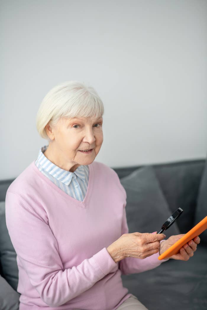 An older woman holding a magnifying glass