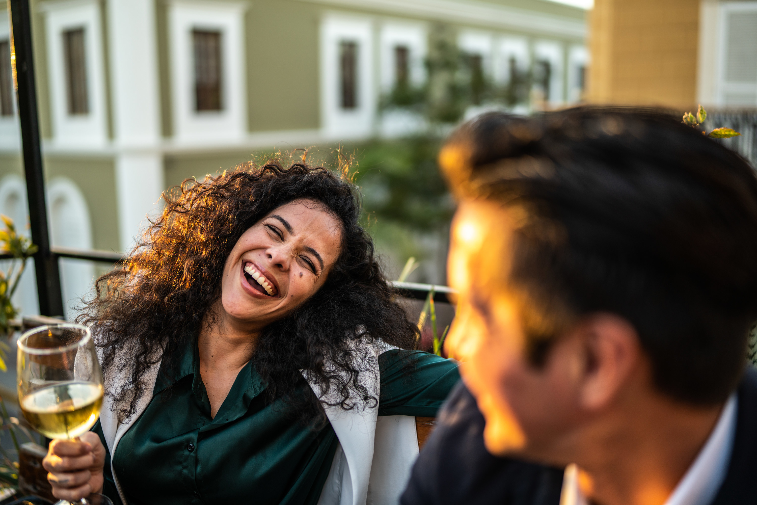 couple drinking and laughing at a rooftop bar