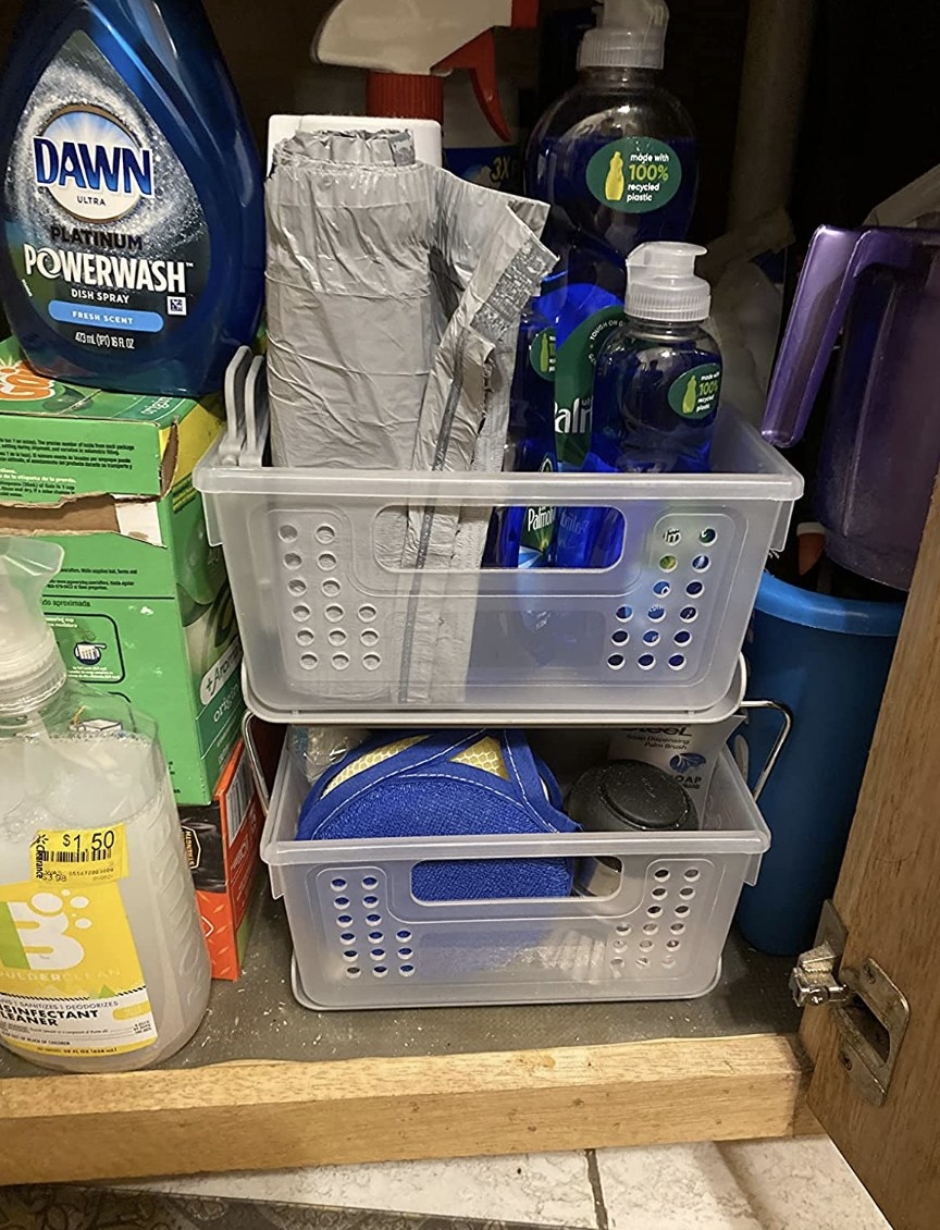reviewer photo showing the cabinet storage drawers filled with cleaning supplies under their sink