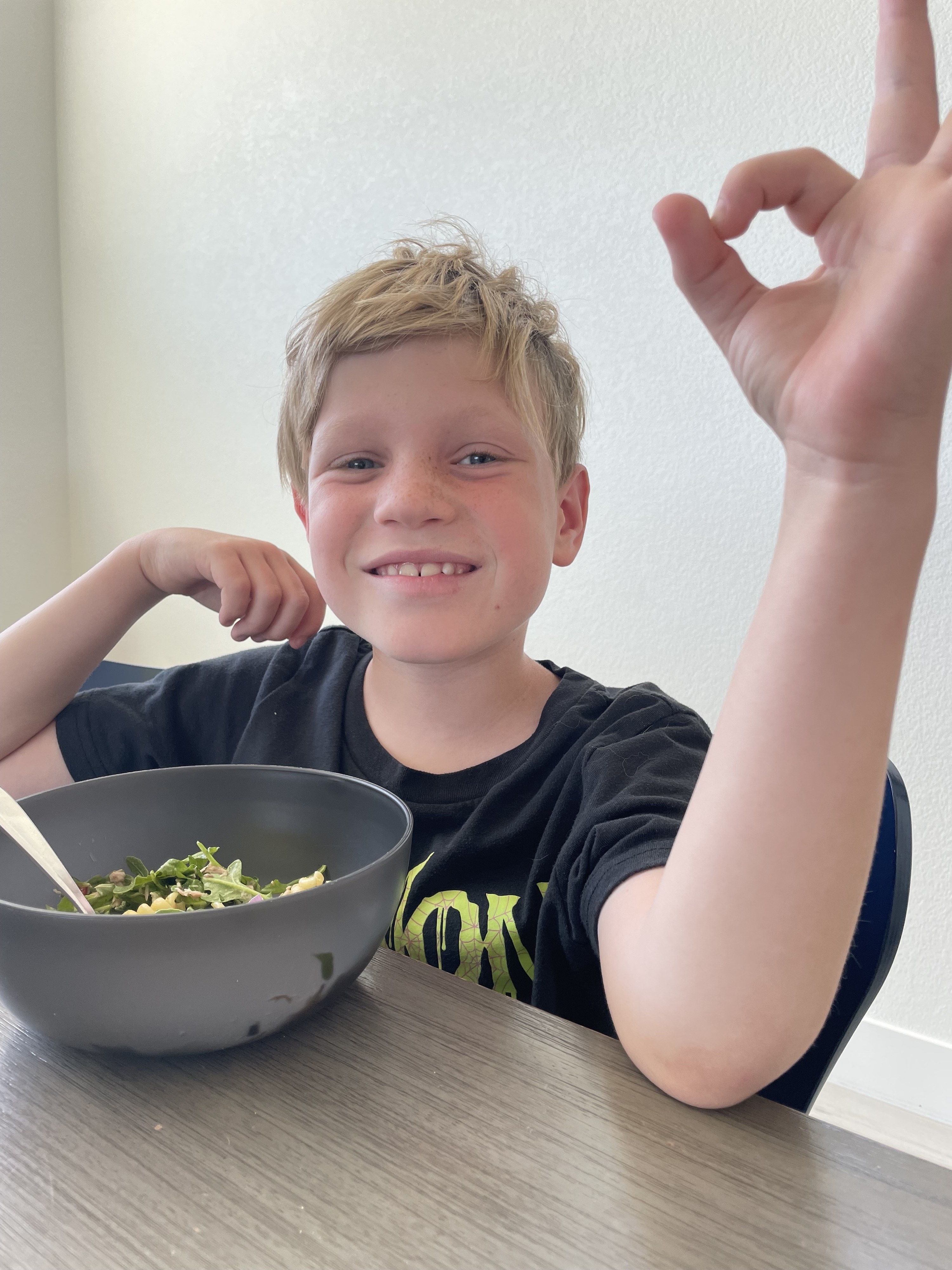 The author&#x27;s son eating lunch and giving an A-OK gesture