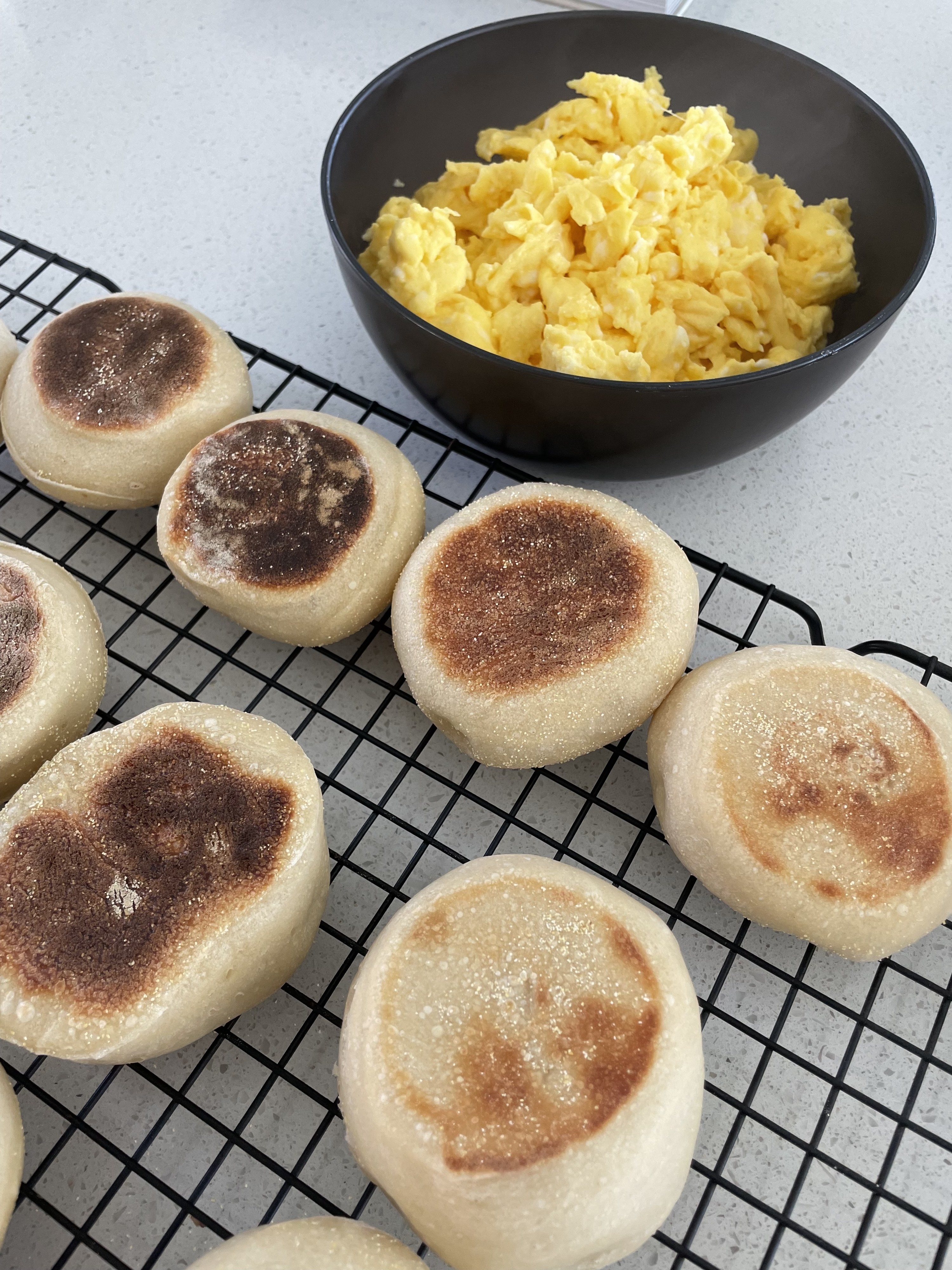 English muffins alongside a bowl of scrambled eggs