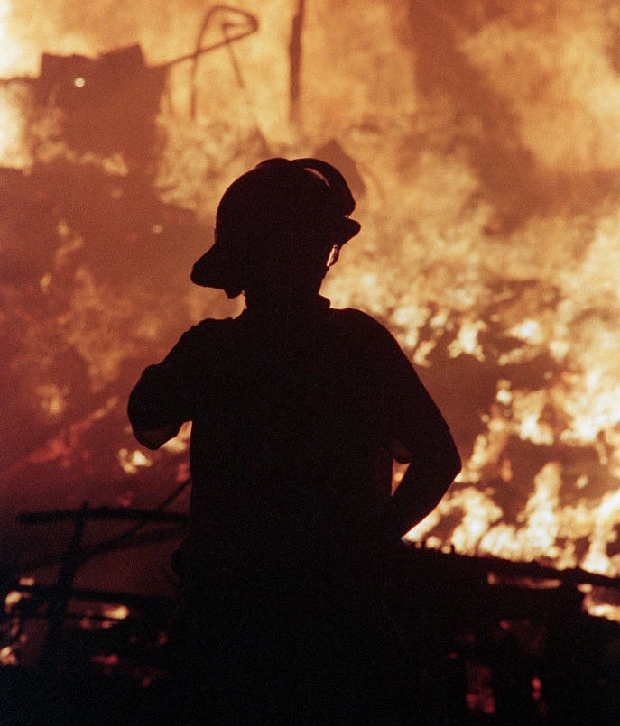 firefighter in front of a house on fire
