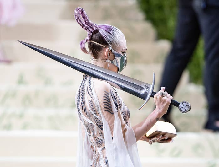 her holding a large sword at the met
