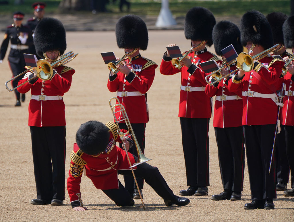 A trombonist for Band of the Welsh Guards getting up after fainting