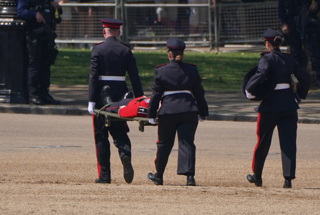 Medics carrying a member of the Band of the Welsh Guards away on a stretcher