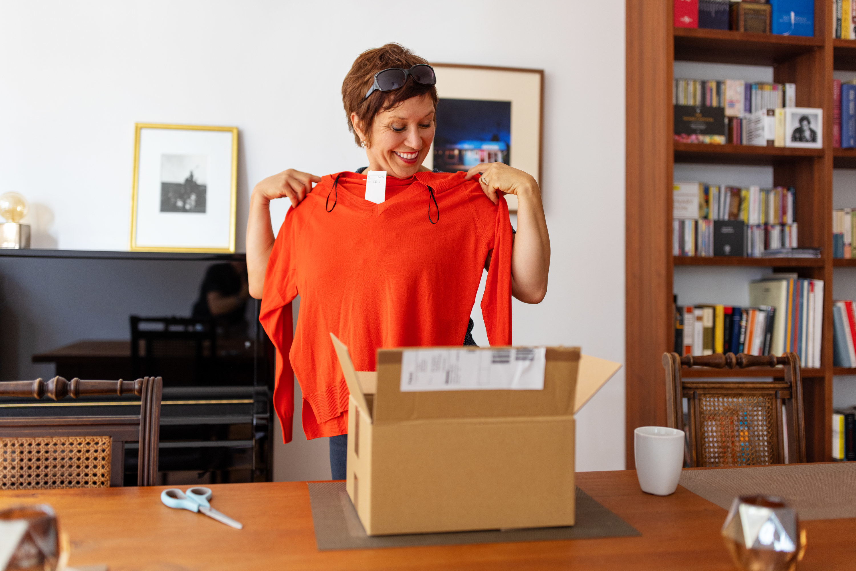 woman taking a sweater out of a package