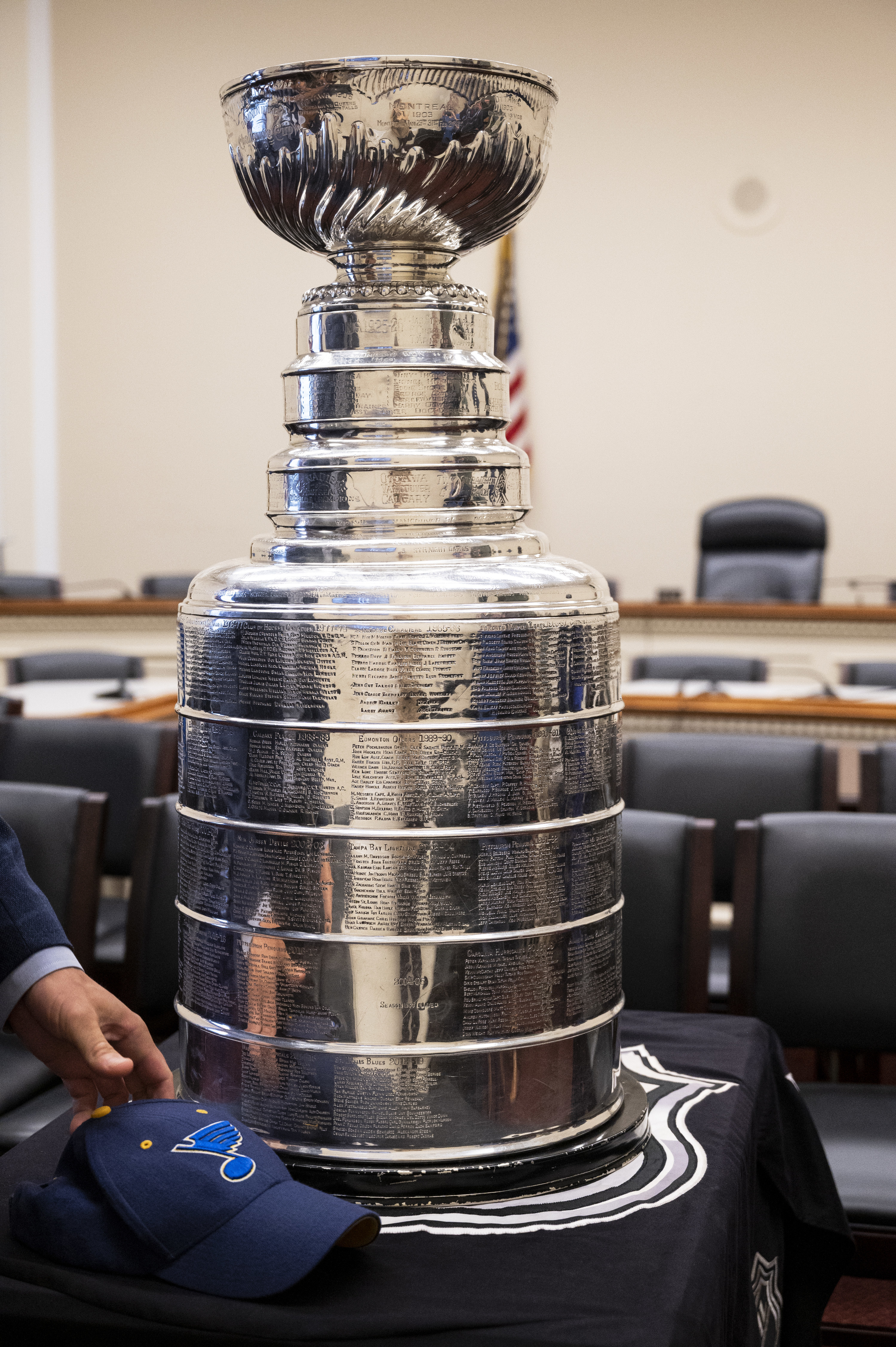 A man puts down a St. Louis Blues hat as the Stanley Cup is on display in the Rayburn Office Building