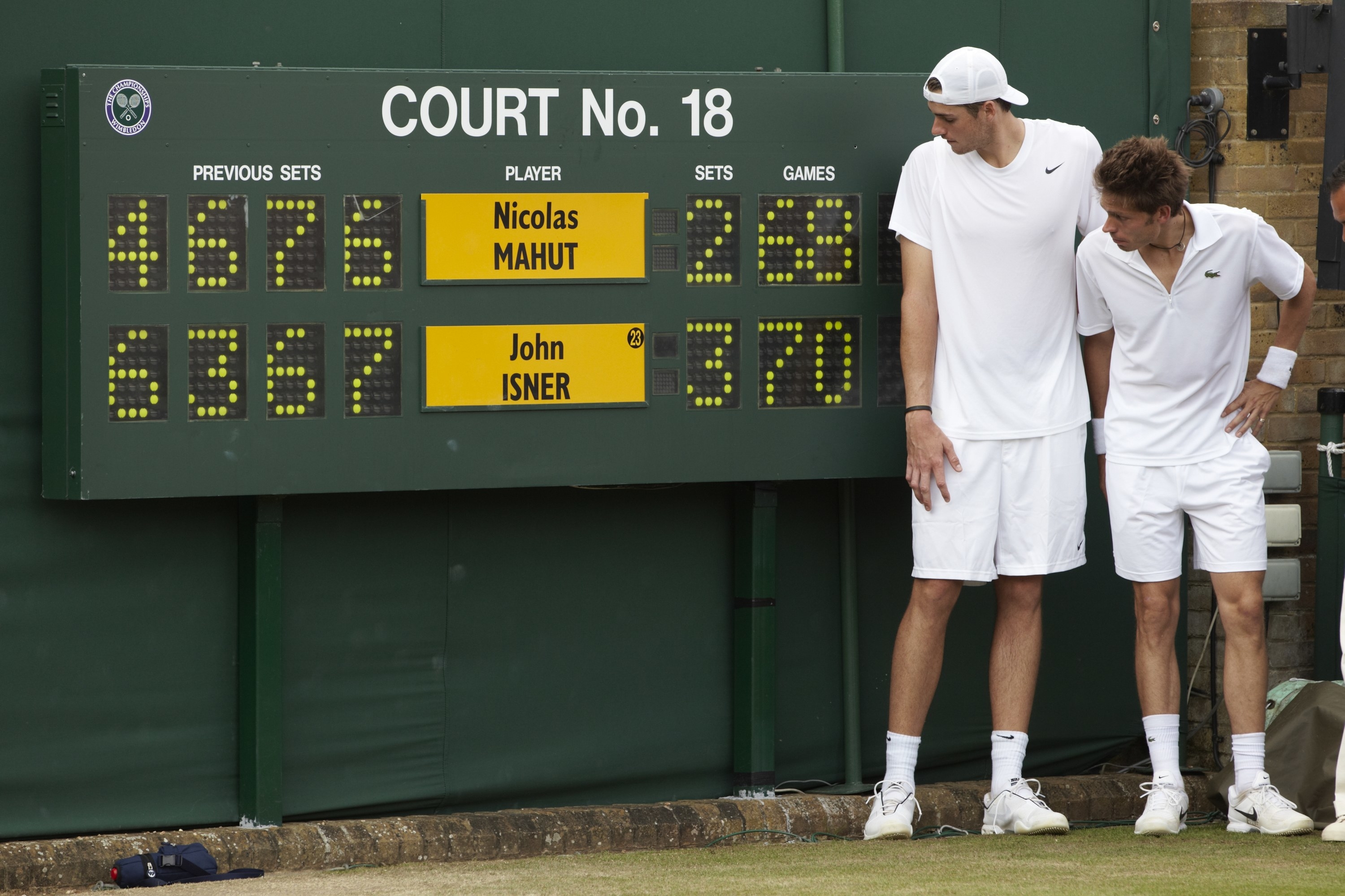John Isner victorious near scoreboard with France Nicolas Mahut after winning Men&#x27;s 1st Round at All England Club