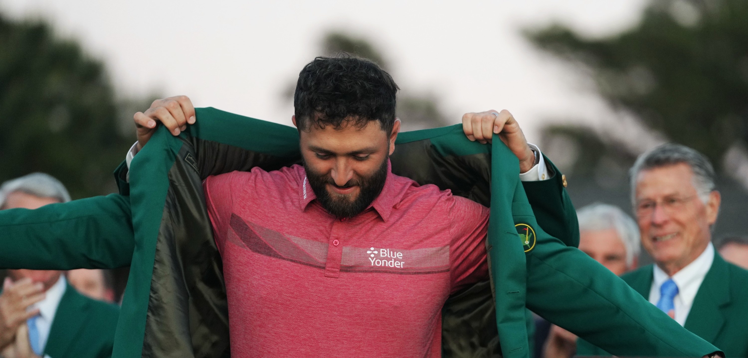 Scottie Scheffler of the United States puts the green jacket on Jon Rahm front of Spain during the awarding ceremony for the 2023 Masters golf tournament at Augusta National Golf Club