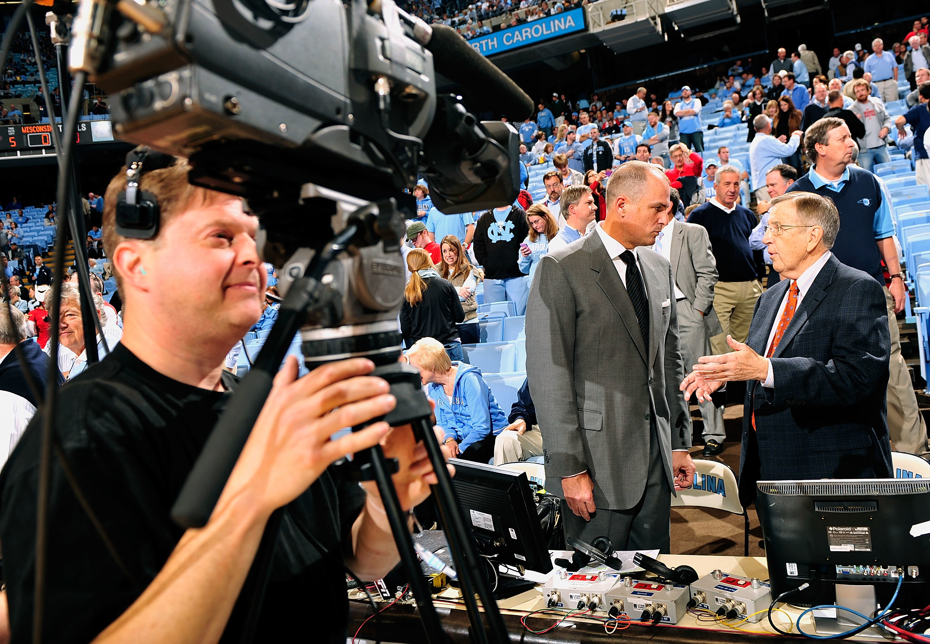 ESPN announcers Jay Bilas and Brent Musberger talk before a game between the North Carolina Tar Heels and the Wisconsin Badgers at the Dean Smith Center on November 30, 2011