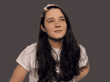 A young woman putting her hand under in chin in a thinking pose