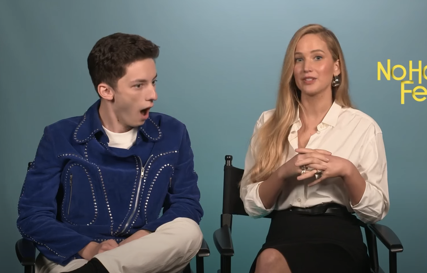 Andrew looking shocked and sitting next to JLaw