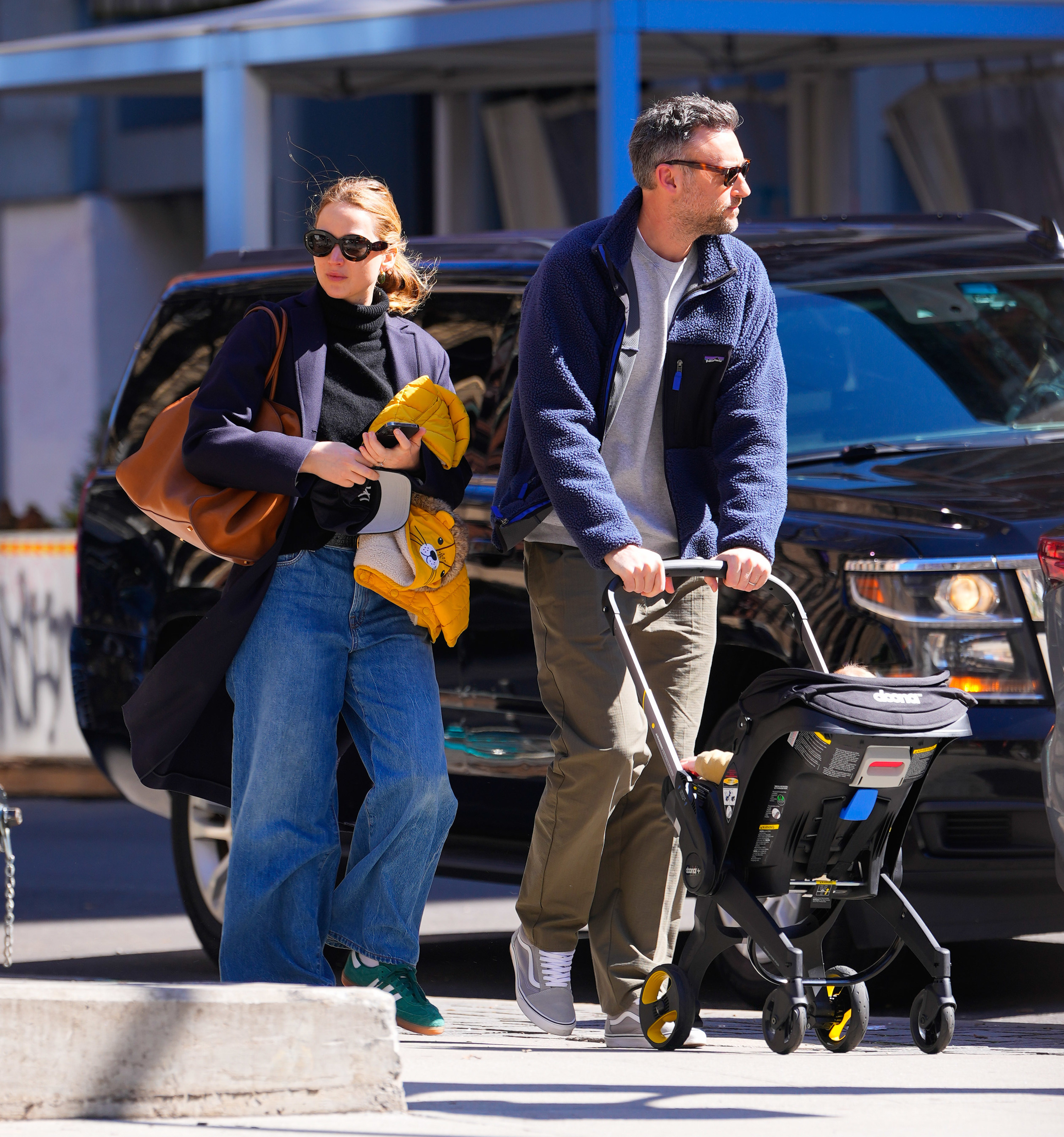 JLaw dressed casually and walking in the street with her husband, Cooke Maroney, who&#x27;s pushing a stroller