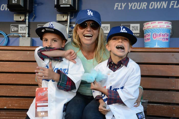 Britney laughs as she holds on to her two sons at a baseball game when they were little boys