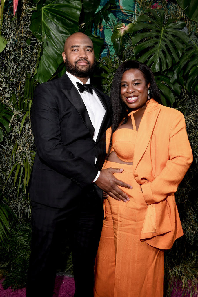 Robert in a bow tie cradles Uzo&#x27;s baby pump